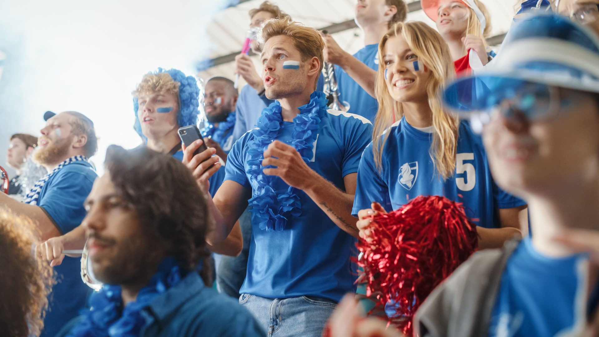 Sport Stadium Soccer Match: Portrait of Excited Caucasian Couple Cheering Team to Win, Use Smartphone to Check App, Bet, Score, Winnings. Crowd Celebrate Goal, Championship Victory
